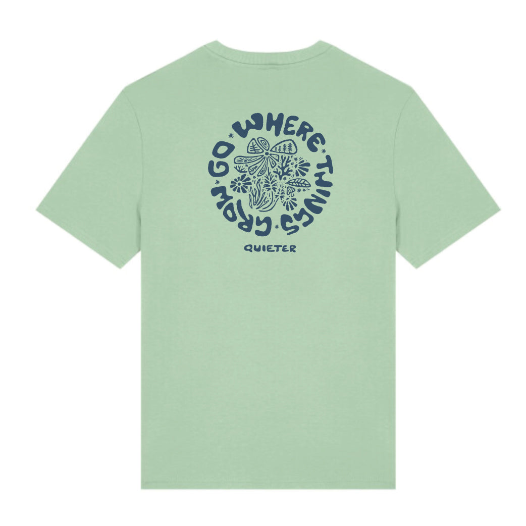 A sage green short-sleeve t-shirt shown from the back, featuring a dark blue circular graphic with a butterfly and the text 'GO WHERE THINGS GROW' with 'QUIETER' printed below.