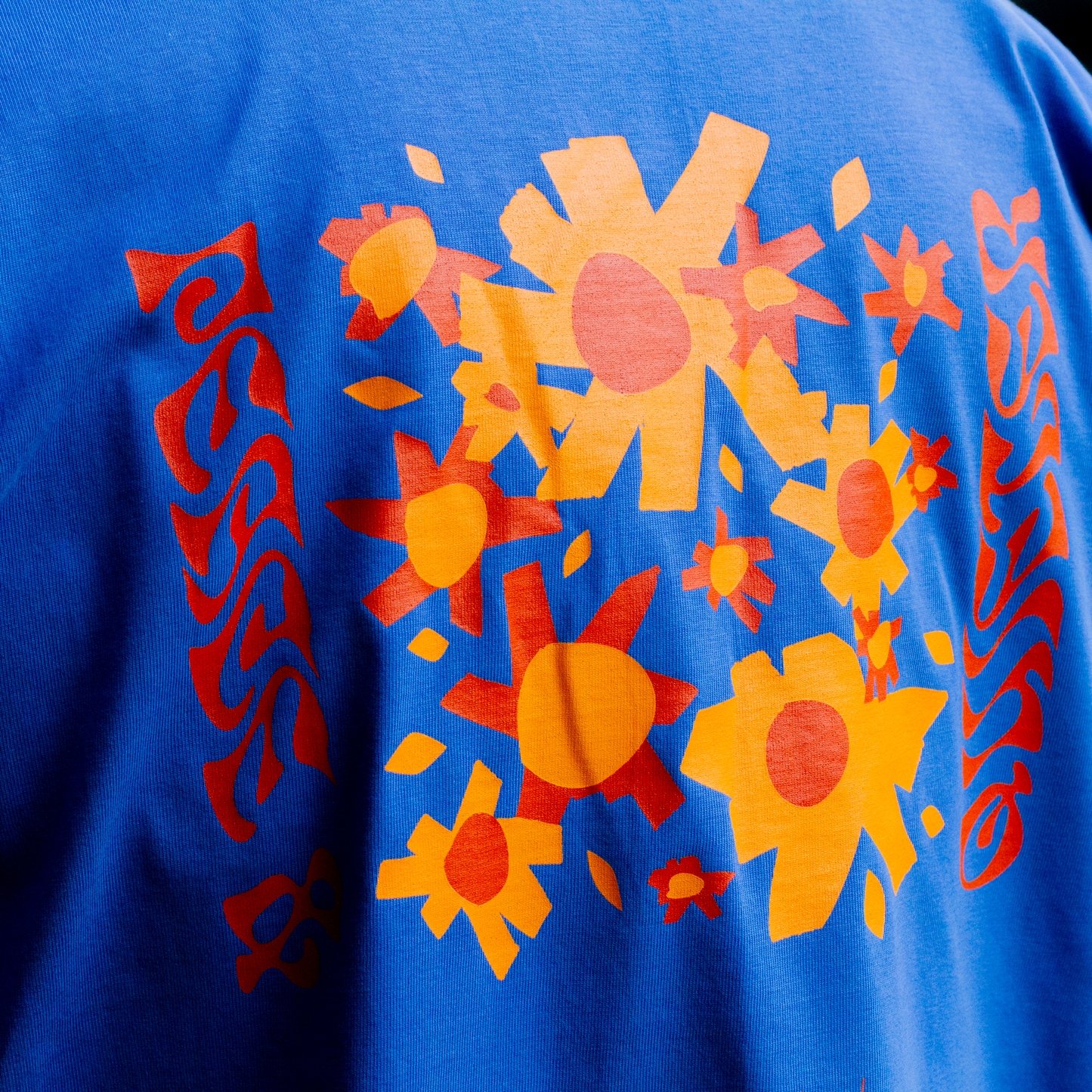 Close-up of screen print detail on QUIETER Peace and Flowers long sleeve