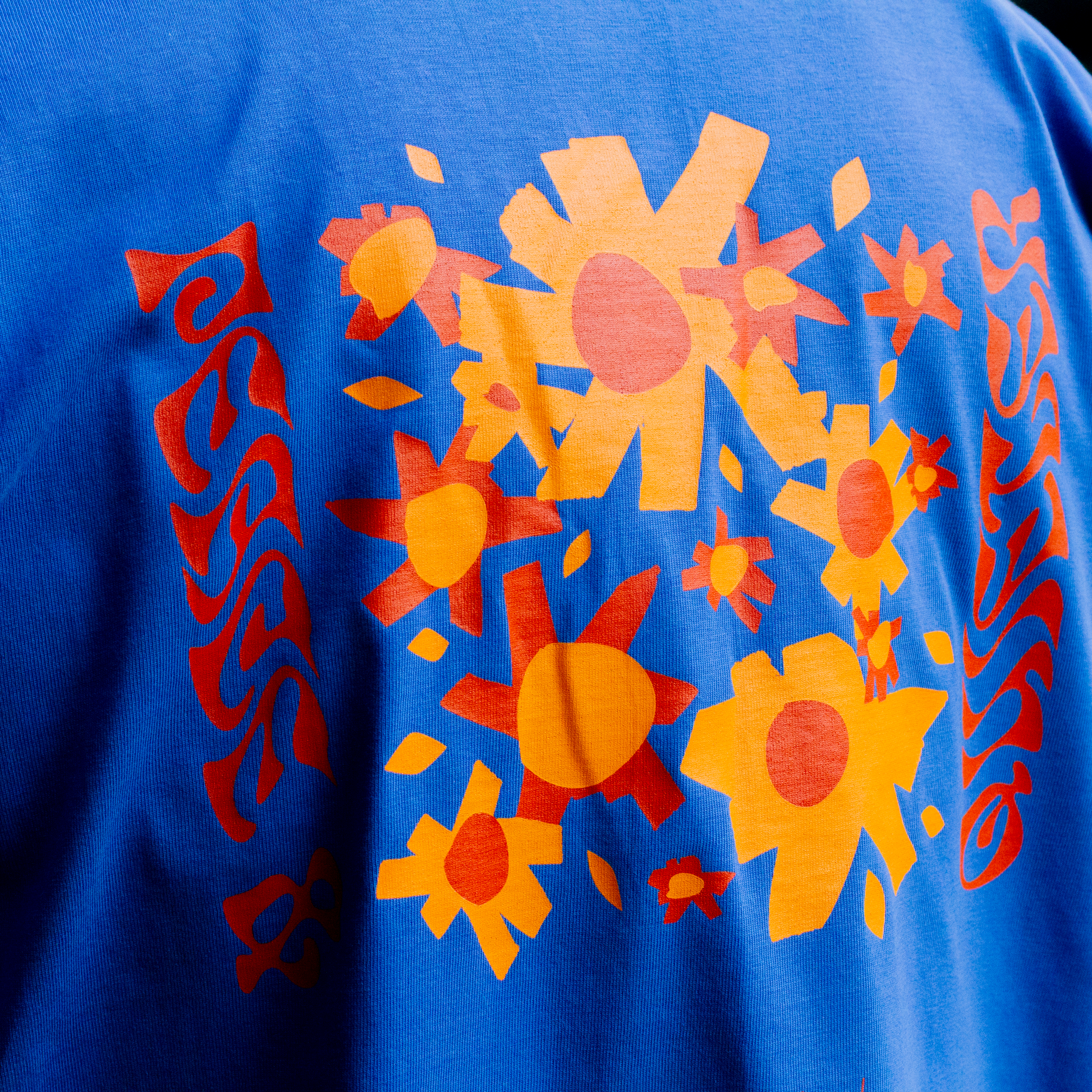 Close-up of screen print detail on QUIETER Peace and Flowers long sleeve