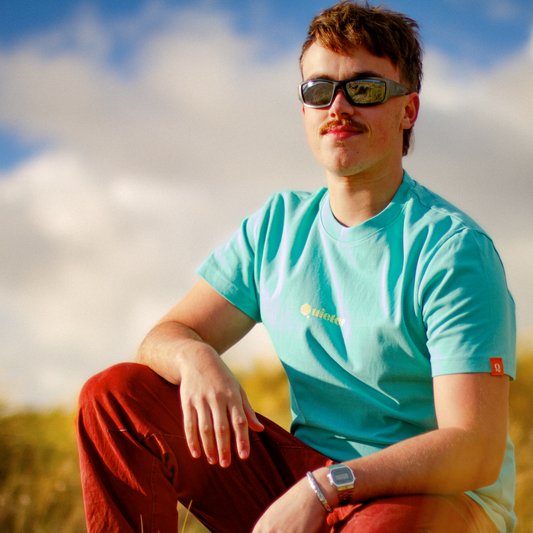 Person wearing QUIETER Switch Off tee in retro reef, front view outdoors